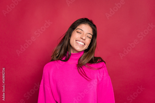 Excited woman celebrating victory against red background © The Attico Studio