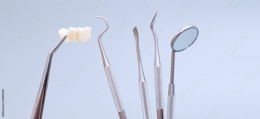 Dental tools and model of teeth on a blue background. Dental care concept. Invisible braces Dental tools and model of teeth on a blue background. Dental care concept. Invisible braces