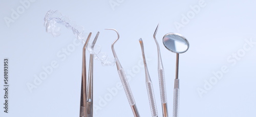 Dental tools and model of teeth on a blue background. Dental care concept. Invisible braces