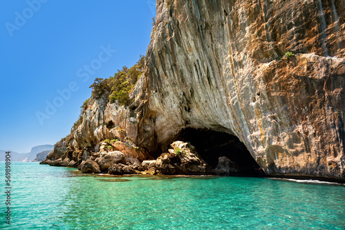 Cliffs and turquoise waters near Grotta del Bue Marino seen from the sea, Sardinia, Italy photo