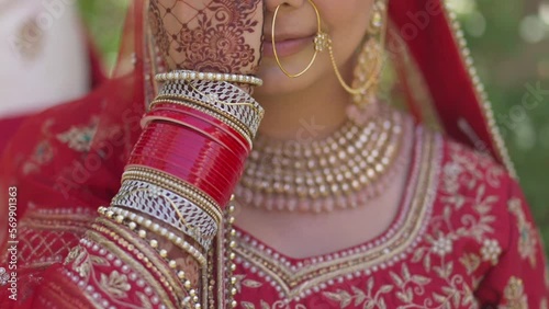 Portrait of a happy Indian bride covering her face with her hand, Hindi on her hand