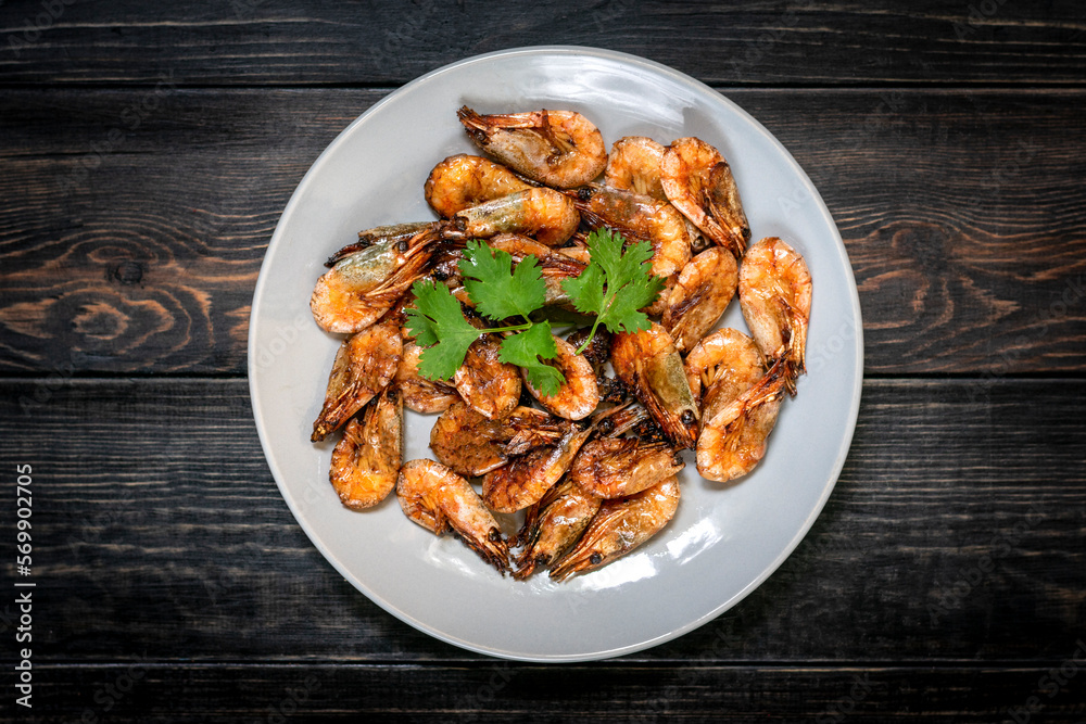 fried shrimp with soy sauce, garlic in gray plate on wooden table Seafood Traditional thai food fried shrimp with soy sauce, garlic in gray plate on wooden table Seafood Traditional thai food