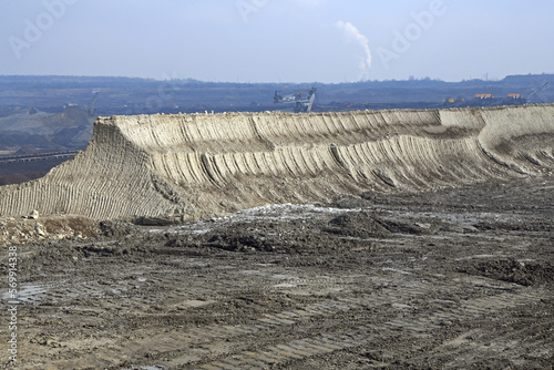 Bucket-wheel excavator during excavation at the surface mine. Huge excavator on open pit mine.