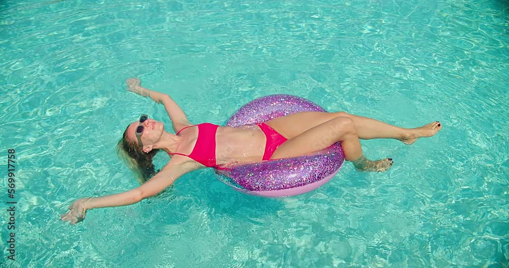 Pretty woman swim in the pool, sunbathes, swimming in hot summer day. Relax, Travel, Holidays, Freedom concept. Slim female relaxing along sea water waves on vacation