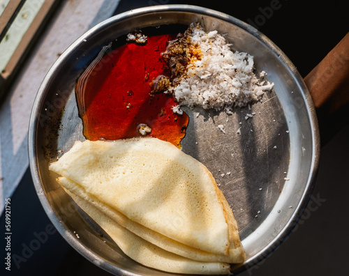 Close up of popular indian food called dosa or dosha with coconut and date juice made mithe photo