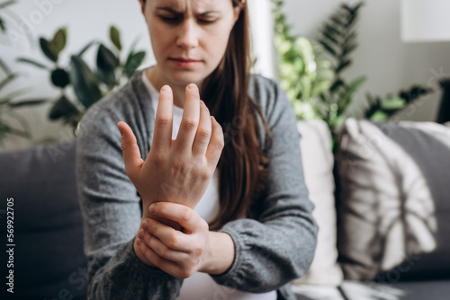 Konstfotografi Selective focus of tired young pregnant female expecting baby suffering pain on hand and fingers sit alone on couch at home, arthritis inflammation, future mother massaging wrists