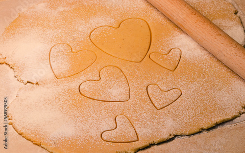 Valentine's day heart shaped cookie from ginger raw dough with flour and rolling pin