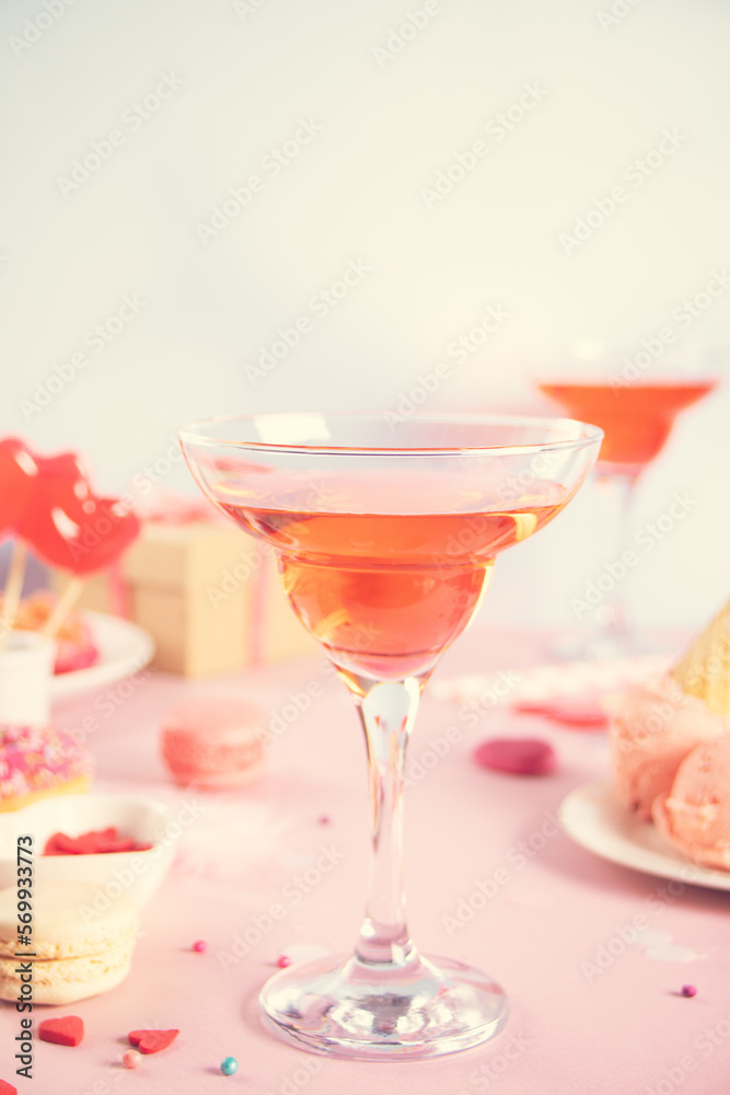 Romantic sweet dessert table with glass of pink wine, waffles, donut, ice cream, macaron, lollipop, candies. Valentine's day concept Romantic sweet dessert table with glass of pink wine, waffles, donut, ice cream, macaron, lollipop, candies. Valentine's day concept