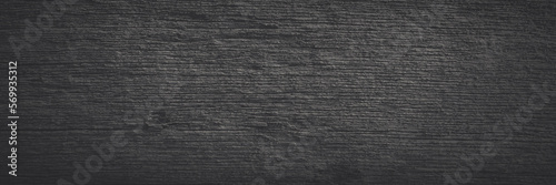 Old wood texture. Weathered rough gray surface of a dry wooden beam. Faded dark wide panoramic background for design. Shaded vintage texture with vignette.