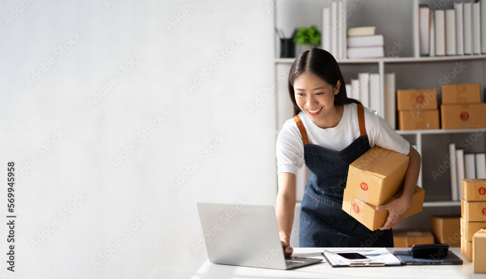 Startup small business entrepreneur of freelance Asian woman using a laptop with box Cheerful success online marketing packaging box and delivery SME idea concept. - obrazy, fototapety, plakaty 