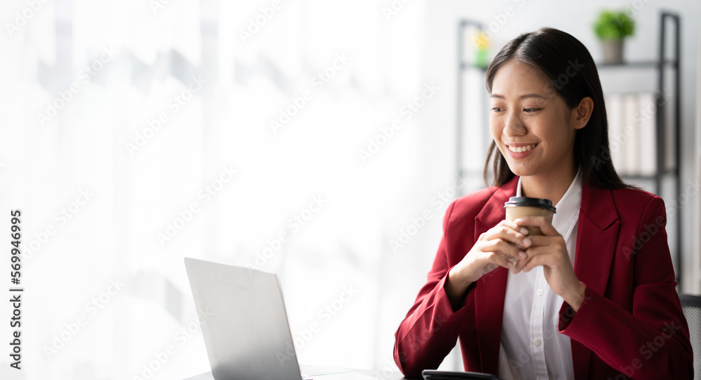 Portrait of young Asian businesswoman working and holding hot coffee cup in the office room. Portrait of young Asian businesswoman working and holding hot coffee cup in the office room.