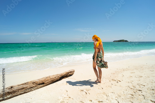 Summer vacation. Carefree joyful woman walking on white sand, relaxing and enjoying tropical beach. Traveler. Tourism.