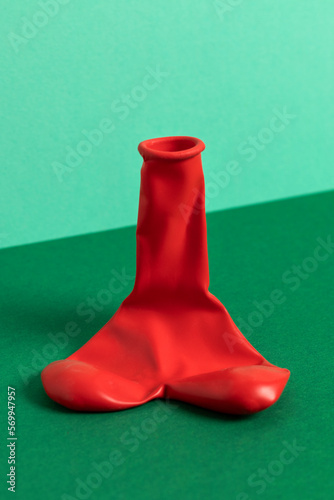 Deflated red balloon. The shape of penis, male potency concept.