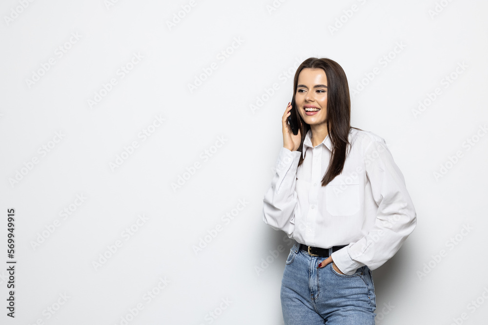 Portrait of a smiling young woman talking on mobile phone isolated over white background Portrait of a smiling young woman talking on mobile phone isolated over white background
