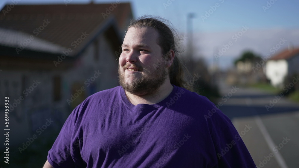 Positive overweight man walking outside exercising. A fat positive person losing weight outdoors strolling. Thoughtful pensive expression Positive overweight man walking outside exercising. A fat positive person losing weight outdoors strolling. Thoughtful pensive expression
