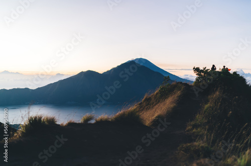 Anonymous hikers resting on mountain peak