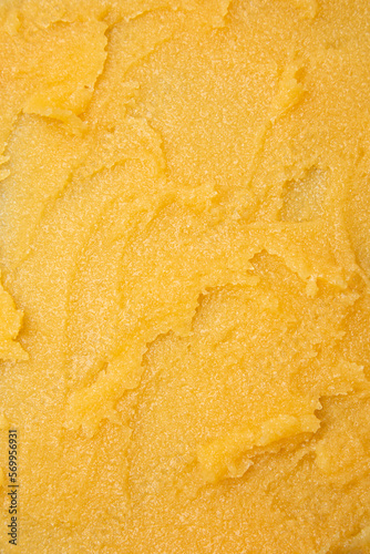 The texture of a yellow fruit sugar body scrub. Flat lay, selective focus