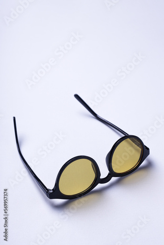 Sunglasses with yellow lenses upside down on a white background.