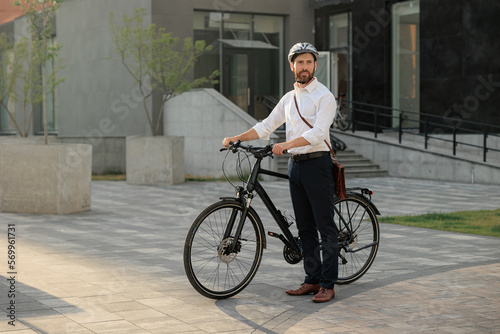 Caucasian businessman commute in shirt with bike outdoors in city.