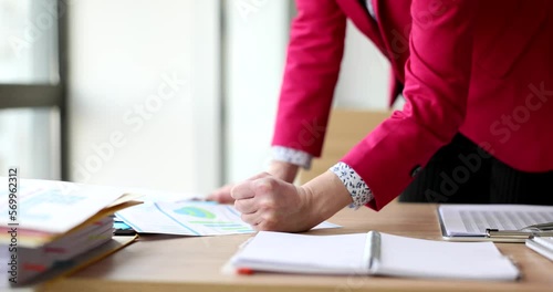Businesswoman tossing business documents chart and clenching hand into fist on desktop photo