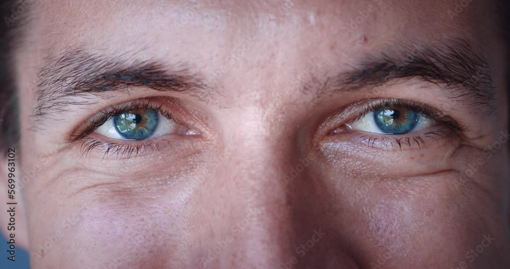 Close up of smiling male face. Caucasian young male with blue eyes smile and looking at camera. Vision of millennial male 30, slow-motion, macro extreme close-up.