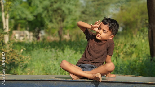 Child practicing yoga in the park in day time. Boy is doing yoga in clean and green environment and fresh air. © thala bhula