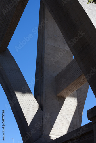 Detail photograph of an arched bridge in the Arroyo Seco, Pasadena, California showing the play of light and shadow on concrete and steel supports,