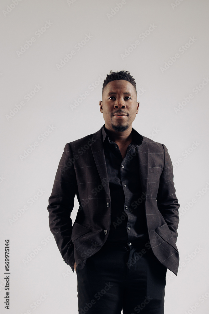 Young african businessman stands against gray background. Young african businessman stands against gray background.