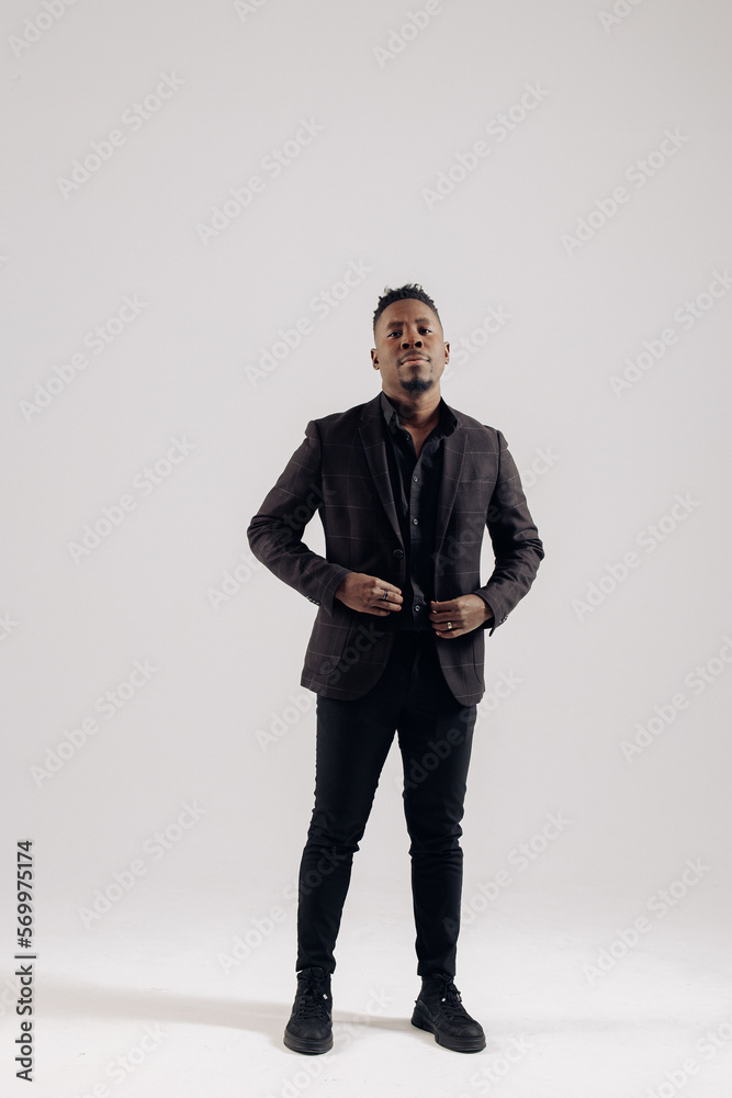 Young african businessman stands against gray background. Young african businessman stands against gray background.