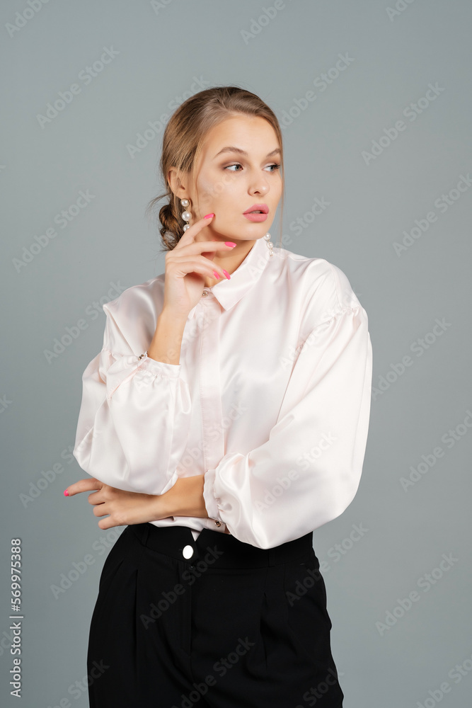 Woman in a blouse and trousers. Studio portrait. Woman in a blouse and trousers. Studio portrait.