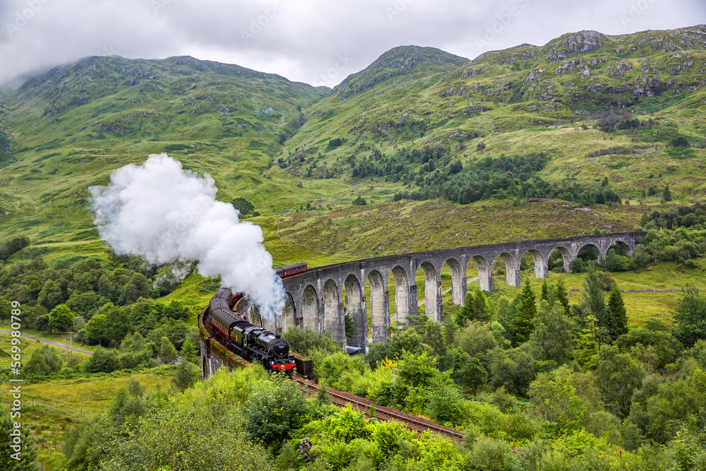 Obraz premium Glenfinnan railway viaduct in Scotland with the Jacobite steam train passing by