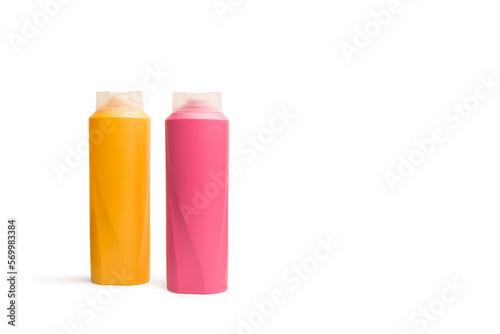 Bote de champú de color rosa y amarillo sobre un fondo blanco liso y aislado. Vista de frente y de cerca. Copy space