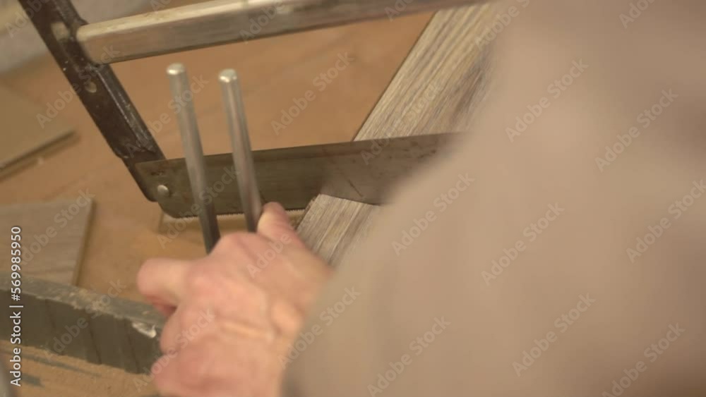 Worker Cuts Piece Of Laminate With Hand Saw Worker Cuts Piece Of Laminate With Hand Saw