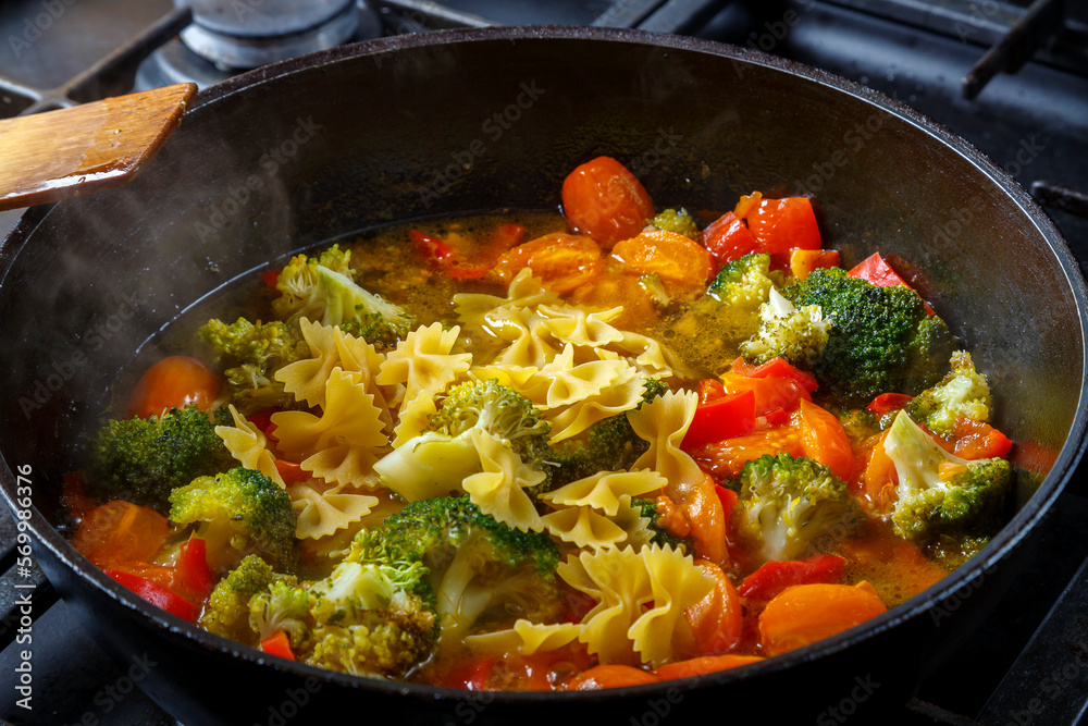 Stewed vegetables beans broccoli tomatoes stewed with spices in a frying pan. Stewed vegetables beans broccoli tomatoes stewed with spices in a frying pan.