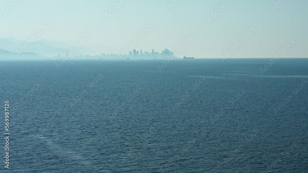 Panoranic view of sea with city on horizin in the haze Panoranic view of sea with city on horizin in the haze
