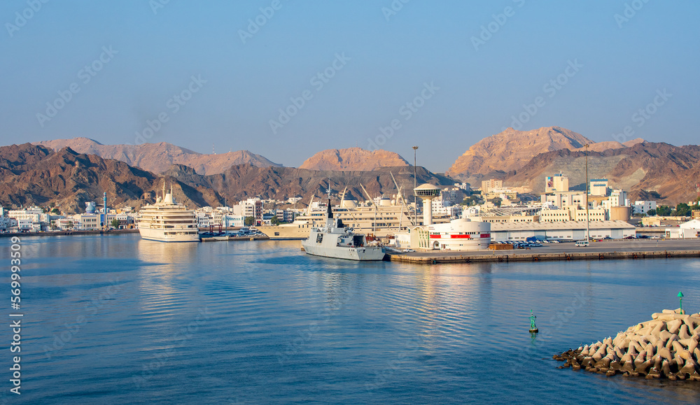 Modern motor yachts in the Muttrah Corniche. Muscat old town and mountains in the background, Oman