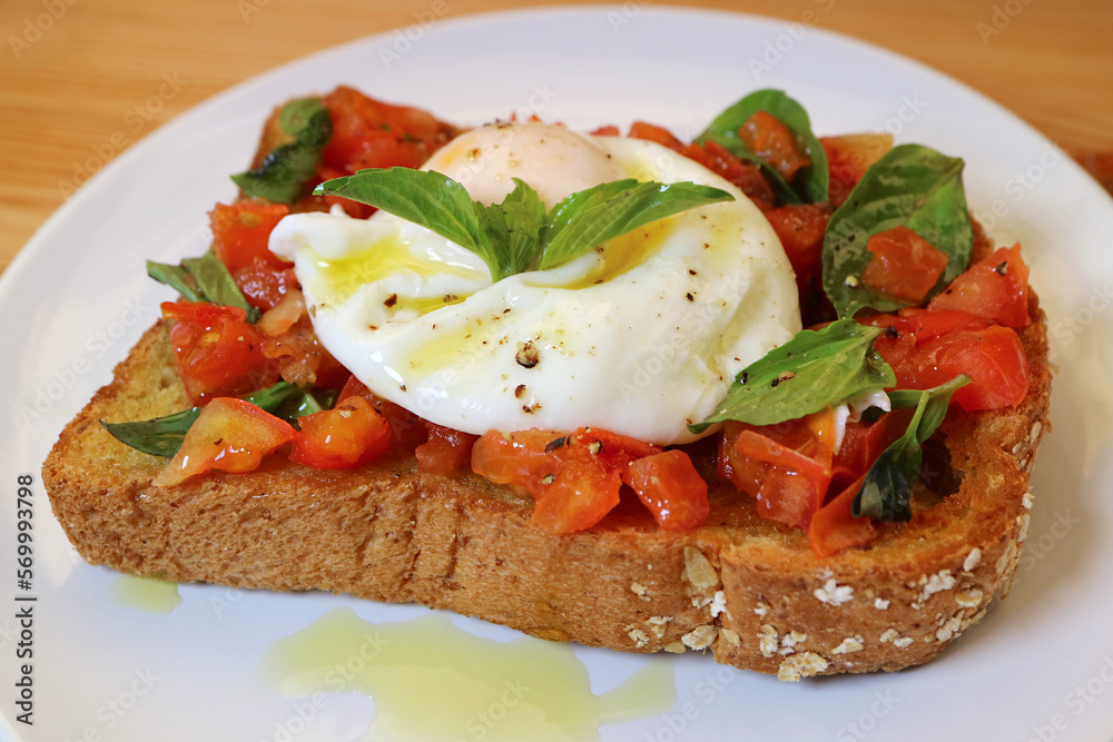 Plate of Tasty and Healthy Fresh Tomato and Basil Toast Topped with Poached Egg Plate of Tasty and Healthy Fresh Tomato and Basil Toast Topped with Poached Egg