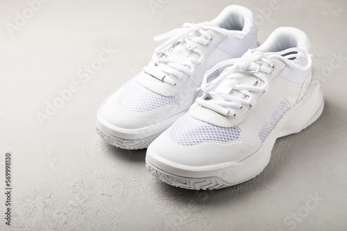 Pair of white shoes on a white texture background. Sport shoes. Unisex. Street style.