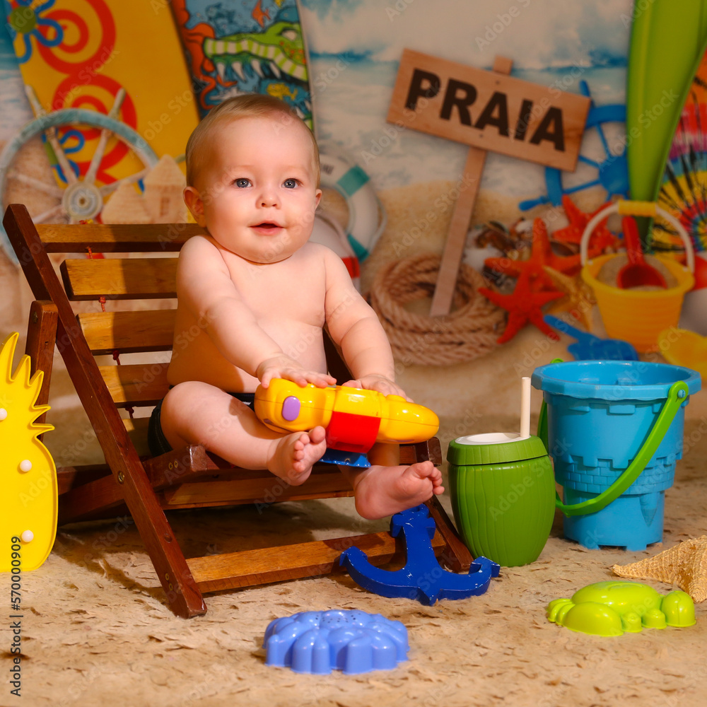 Bebê menino sentado brincando na praia Bebê menino sentado brincando na praia