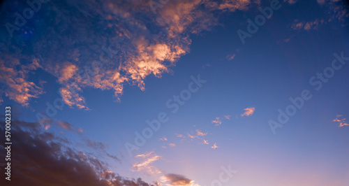 Blue evening sky and orange lighted clouds at sunset