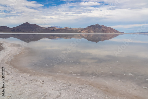 Panoramic view of beautiful mountains reflecting in lake of Bonneville Salt Flats, Wendover, Western Utah, USA, America. Looking at summits of Silver Island Mountain range. West of Great Salt Lake photo