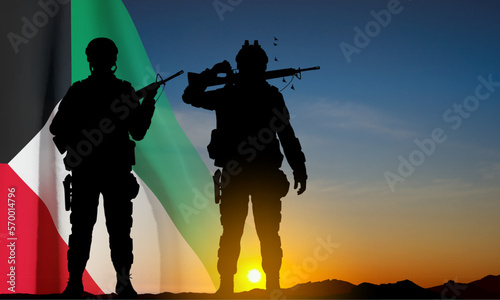 Kuwait flag and the silhouettes of a soldiers on background of sunset. Concept - National, Liberation Days. EPS10 vector