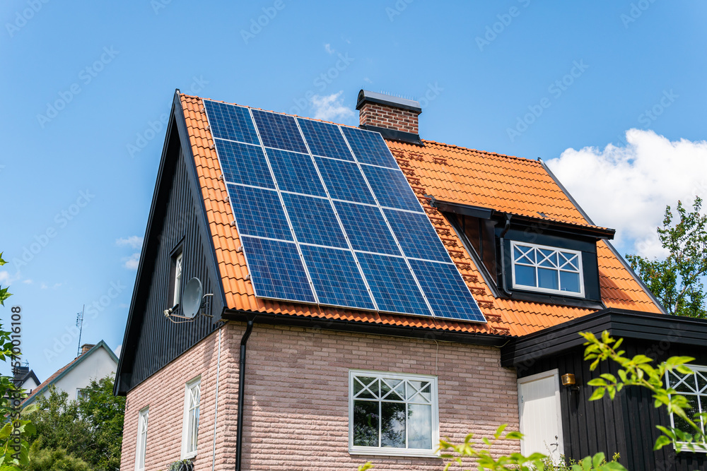 Solar battery panel on a roof of a private house in Europe. Energy-saving technology. Sunny summer day.