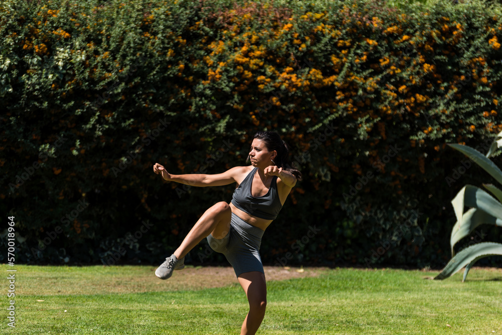 young and beautiful woman doing gymnastics in the garden of her house on a sunny day, yoga, diet, health