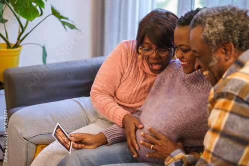 Grandparents proud of their daughter's pregnancy talking with other relatives through the internet. Concept: Family, motherhood, communication