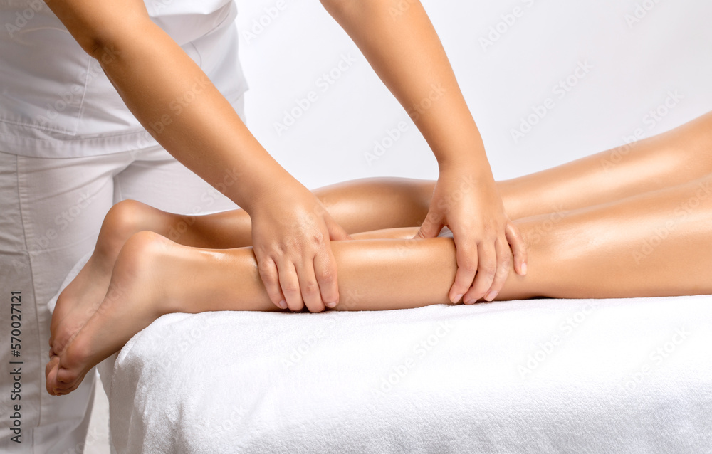 Masseur makes anti-cellulite massage on the legs, thighs, hips and buttocks in the spa. Overweight treatment, body sculpting.Cosmetology and massage concept.