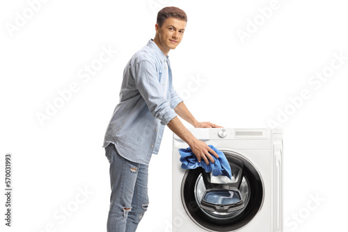 Young man loading a washing machine