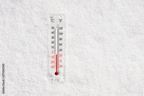 White celsius and fahrenheit scale thermometer in snow. Ambient temperature minus 3 degrees celsius