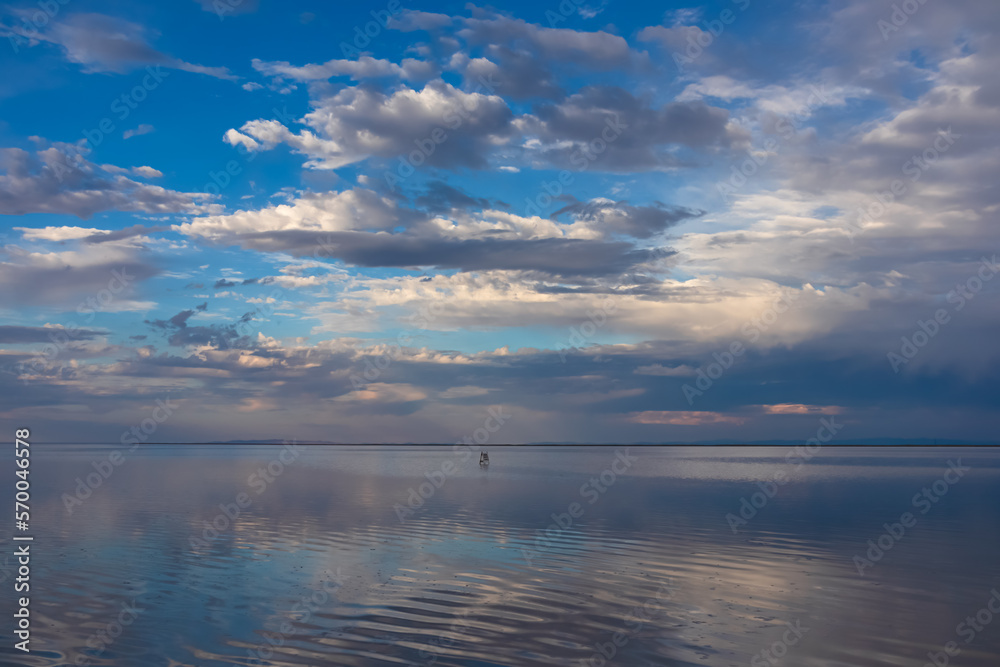 Scenic view of beautiful water reflections in lake of Bonneville Salt Flats at sunset, Wendover, Western Utah, USA, America. Dreamy clouds mirroring on the water surface creating romantic atmosphere