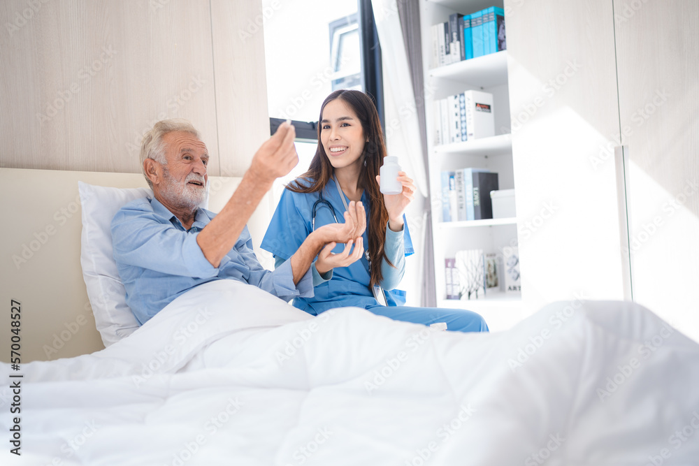 Obraz premium Smiling young nurse in hospital and health care center giving routine medications to happy and cheerful senior patient lying and sitting on bed while having a fun conversation